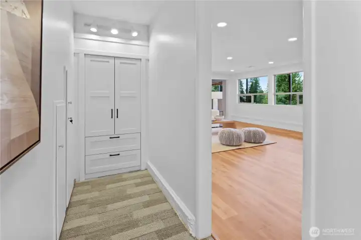 Hallway with charming built-in wardrobe and storage cubbies under the stairs.