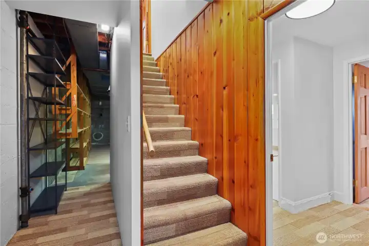 Staircase ceiling, hallway landing, and wall leading to the mechanical/utility room was recently enlosed and drywalled to modernize and brighten this part of the home. Door to the right leads to the lower bedroom and around the corner on the right to the rec room.