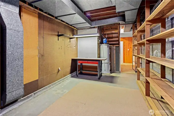 Oversized unfinished utility space with potential for hobby room, storage, or future laundry. Full-wall storage shelving for seasonal gear, luggage, or create a full-blown workshop.