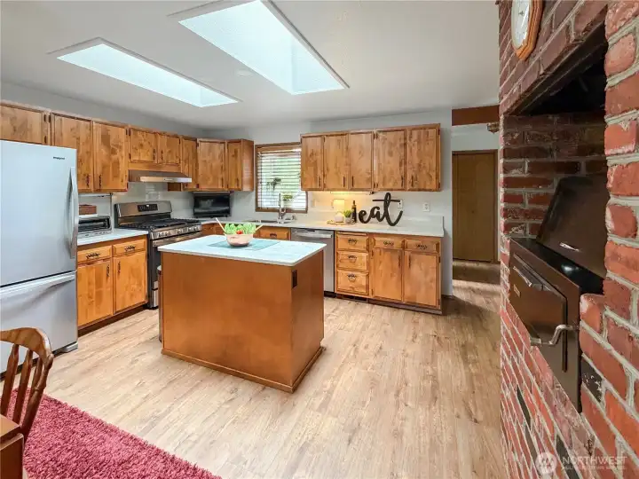 Full view of kitchen.  Lots of cabinets.  Newer appliances all stay. Charming garden window above sink.
