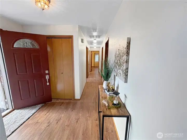 Entry with ample closet, view down hallway to bedrooms and baths.  Primary is at the end of the hallway.