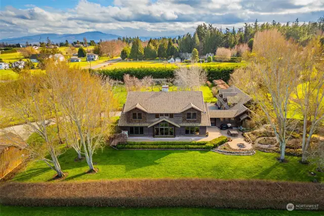 Back view of the home. Gorgeous grounds with fruit trees, gardens, green house, and more.