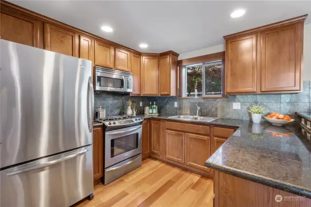 Chef's kitchen includes gas cooktop, granite counter tops and ceiling-height cabinets.