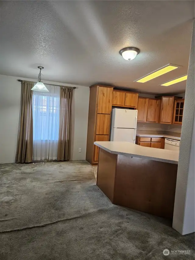 Carpet allowance at closing. Living room looking into dining room and kitchen.