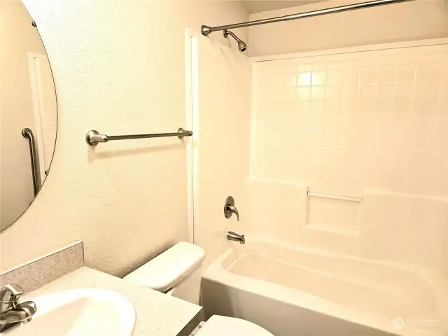 Main bath off hall has its own bathtub.