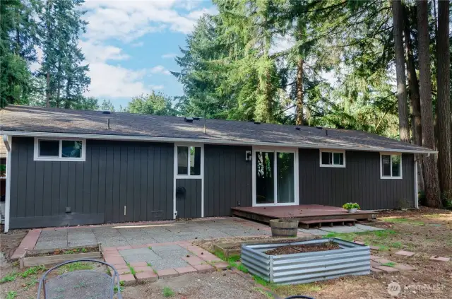 Back of the Home Showing the Trex Deck, Paved Patio and Raised Beds