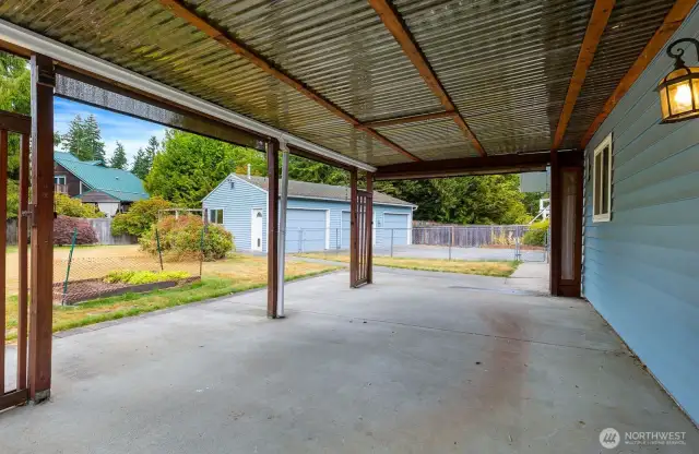 Covered back patio looking towards the detached garage/shop.
