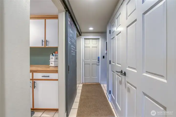 Hallway off kitchen: double door closet, laundry room, stairway to upper level and access to the 2+ car garage.