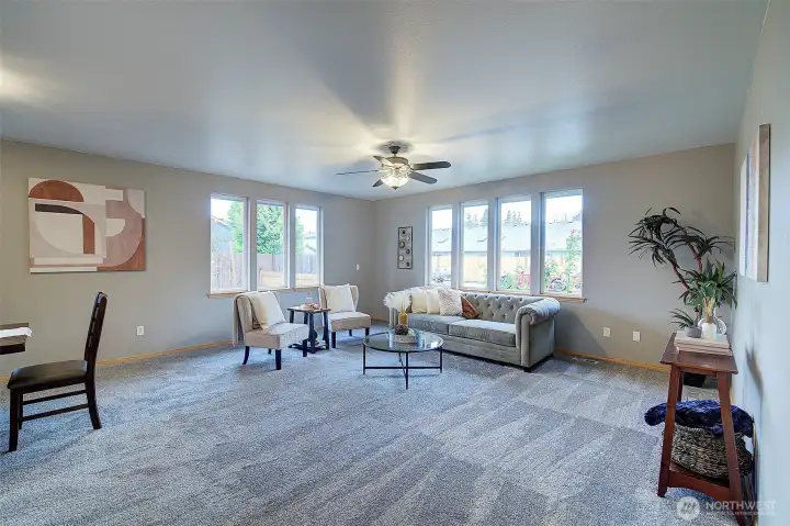 The living room features many windows that bring in lots of natural light.