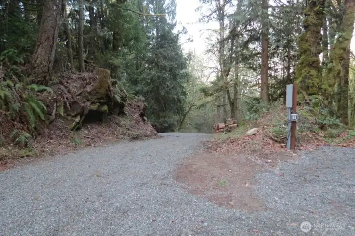 Driveway going down to road from cleared area with power box 1