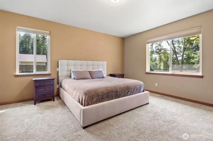 Large primary suite positioned on the west wing of the home next to the kitchen.