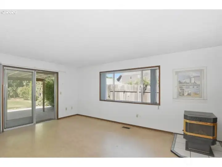Family room with sliding door to the fenced  backyard and a pellet stove.