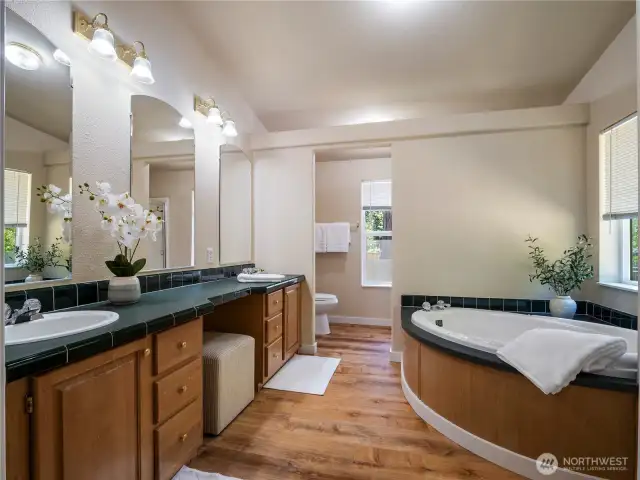 Primary bathroom with double vanities, soaking tub, separate shower, and spacious linen closet.