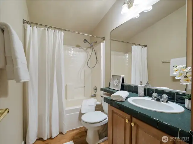 Hall bathroom with tub/shower, single vanity and cabinets for extra storage.