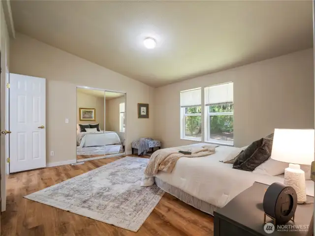 The primary bedroom is spacious and bright, with vaulted ceilings, LVP flooring, walk-in closet, and 5-piece primary bath.