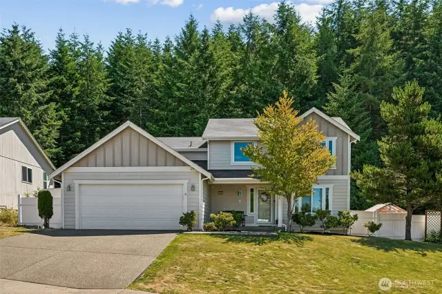 Front view of home, I love the vinyl fencing and huge trees behind this beautiful home.