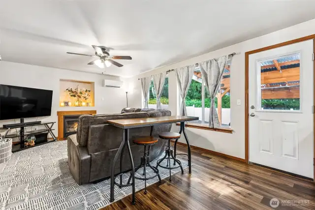 View from the kitchen to the family room, so much to love! Large room, huge windows, ceiling fan, Ductless Mini Split and fireplace for year-round comfort.