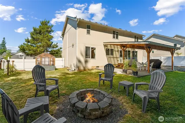 Rearview of the yard showcasing the firepit and greenhouse.