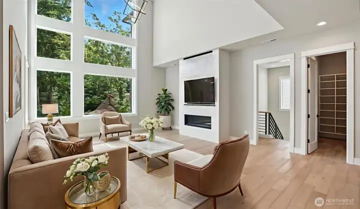 Awe-inspiring Great Room with its mesmerizing 20' ceiling, and sleek modern fireplace framed by breathtaking custom tile work! Door to the right in this photo leads to the Great Suite on the Main Level. Virtually staged