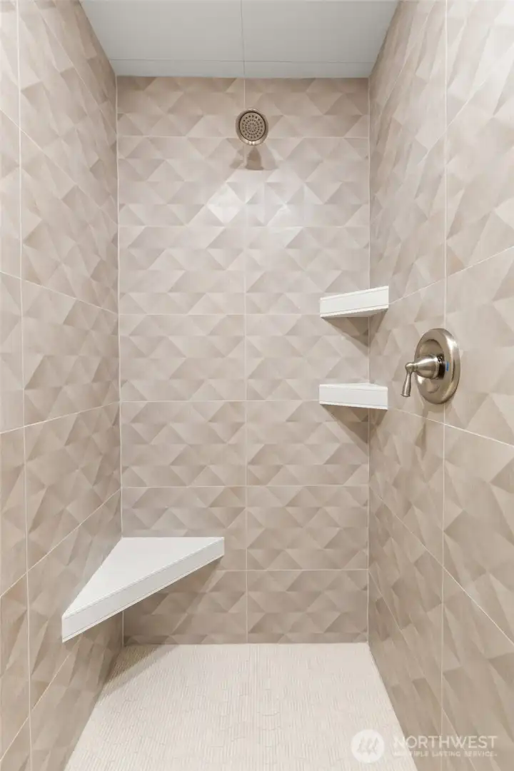 Walk in shower with floor to wall ceramic tiles.