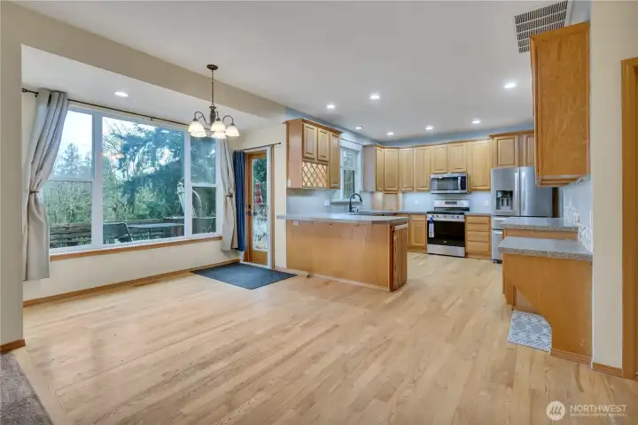 Solid oak floors in the kitchen and dining room. Kitchen appliances are newer and in great shape. Wine rack is on the left. Some paint and a backsplash will make this room really shine!
