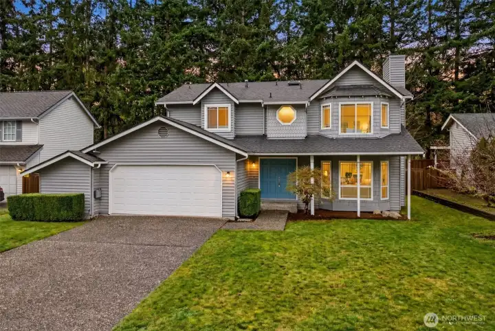 Nestled in the sought-after Sunrise on English Hill neighborhood, this classic two-story home greets you with timeless curb appeal, lush lawn, and warm interior lighting that radiates a welcoming glow at dusk — a stunning first impression from the moment you arrive.