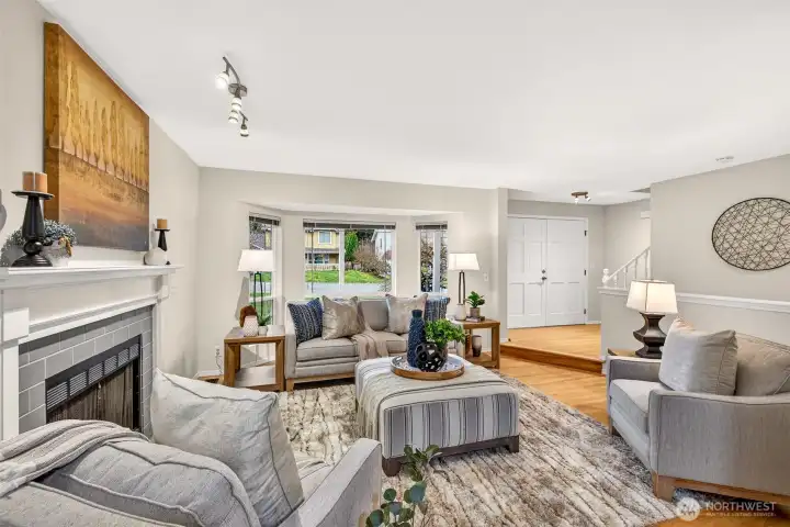 With a cozy fireplace, bay window framing the front yard greenery, and gleaming refinished hardwood floors throughout, the living room offers a relaxed yet refined atmosphere that sets this home apart from the moment you settle in.
