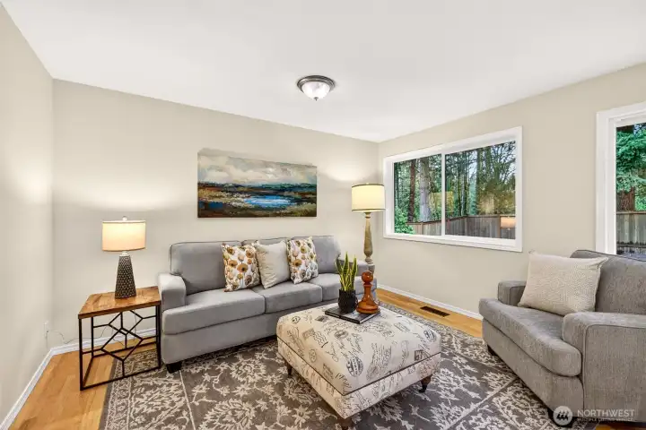 A quiet and versatile lower level family room with hardwood floors, fresh neutral paint, and wooded views through double windows offers the flexibility to serve as a quiet retreat or entertainment space conveniently located to sliding doors to the backyard, or to the kitchen for ease of living.