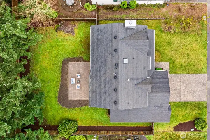 An aerial overview reveals the home's exceptional positioning on the lot — a deep, well-proportioned 8,750 SF parcel with a private patio, open lawn, and mature tree coverage that provides the kind of natural buffer and outdoor space rarely found in this price range in Redmond.