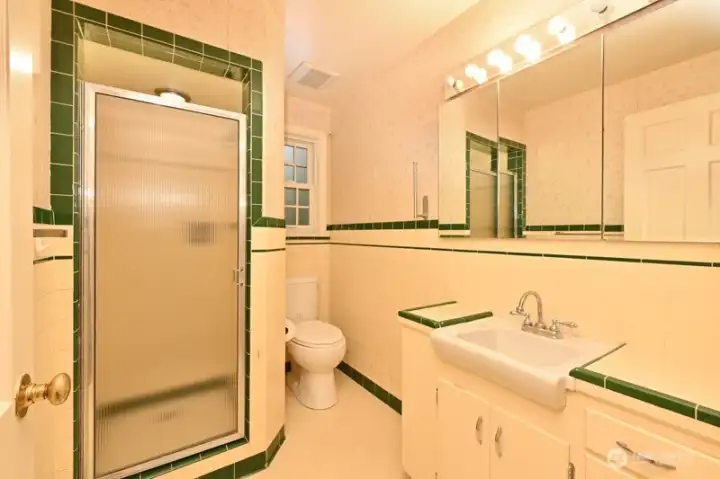 Three-quarter Ensuite Bath with Primary Bedroom. Classic tile, newer window.