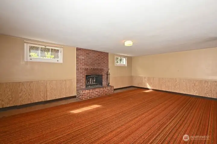 Lower Level Rec Room with wood fireplace. Note windows along south side letting light shine in. Window on the east side not shown from this angle.