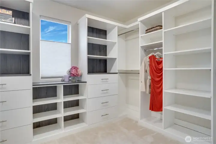 Luxurious custom closet design in the primary bedroom, complete with hanging space, soft close drawers and shelving. All bedrooms have walk-in closets.