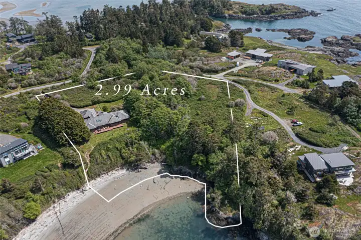 The outlined 2.99-acre parcel illustrates the remarkable scale and waterfront reach of this offering, encompassing lush upland grounds, a private path to the beach, and direct frontage on the sandy cove below. This generous lot provides ample room to expand, landscape, or simply enjoy the unmatched privacy that only acreage on San Juan Island can deliver.
