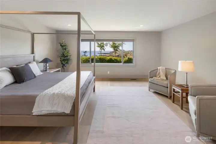 Bathed in natural light, the spacious primary bedroom invites relaxation with an oversized window capturing the quintessential San Juan Island waterfront vista.