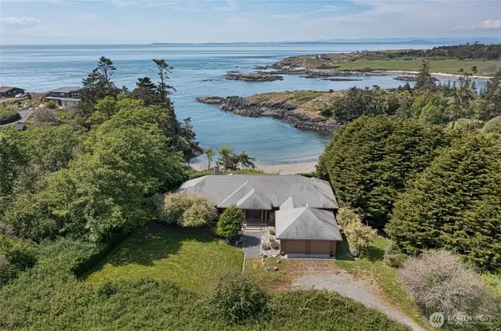 Perched above its own private beach cove, this thoughtfully designed single-level home is framed by lush Pacific Northwest greenery, offering an unparalleled blend of natural beauty, seclusion, and direct waterfront access that defines the ultimate island lifestyle.