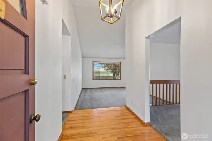 Classic hardwoods and versatile spaces. This inviting entry highlights the home’s rich wood flooring and abundant natural light. To the right, discover a flexible "extra" room—perfect for a family room, den, or library—featuring a focal-point fireplace for chilly PNW evenings. Virtually Staged. Classic hardwoods and versatile spaces. This inviting entry highlights the home’s rich wood flooring and abundant natural light. To the right, discover a flexible "extra" room—perfect for a family room, den, or library—featuring a focal-point fireplace for chilly PNW evenings. Virtually Staged.