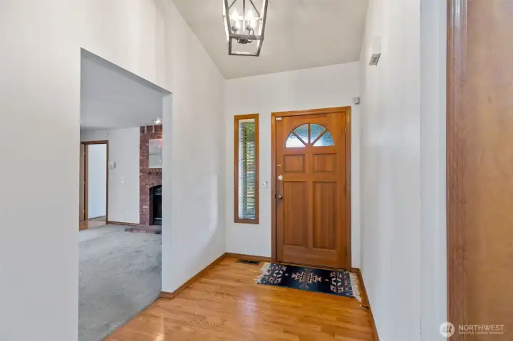 A warm welcome awaits. Stepping through the front door, you’re greeted by gleaming hardwood floors that flow throughout the main living areas. The open-concept entry provides a direct sightline into the spacious living room, while a wide opening to the right leads to a cozy secondary living space anchored by a classic fireplace. A warm welcome awaits. Stepping through the front door, you’re greeted by gleaming hardwood floors that flow throughout the main living areas. The open-concept entry provides a direct sightline into the spacious living room, while a wide opening to the right leads to a cozy secondary living space anchored by a classic fireplace.