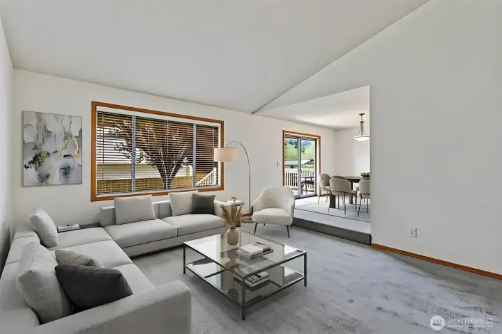 Step down into this inviting heart of the home, where vaulted ceilings and a lowered floor height create a sophisticated, cozy atmosphere. This vantage point emphasizes the home’s open flow, offering clear views into the dining room and out toward the lush backyard through oversized windows. Virtually staged. Step down into this inviting heart of the home, where vaulted ceilings and a lowered floor height create a sophisticated, cozy atmosphere. This vantage point emphasizes the home’s open flow, offering clear views into the dining room and out toward the lush backyard through oversized windows. Virtually staged.