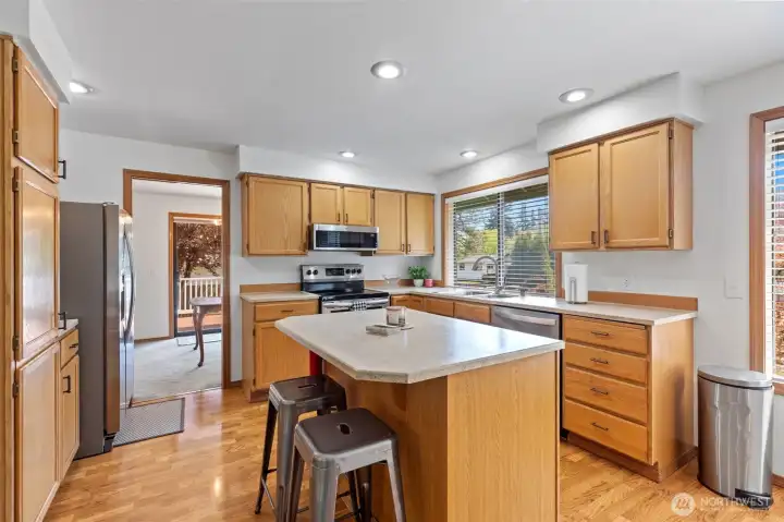 Featuring a practical island for two and beautiful hardwoods, this kitchen is a testament to the home's meticulous maintenance. South-facing windows keep the space bright, while the open layout to the family room ensures the chef is always part of the conversation. Featuring a practical island for two and beautiful hardwoods, this kitchen is a testament to the home's meticulous maintenance. South-facing windows keep the space bright, while the open layout to the family room ensures the chef is always part of the conversation.