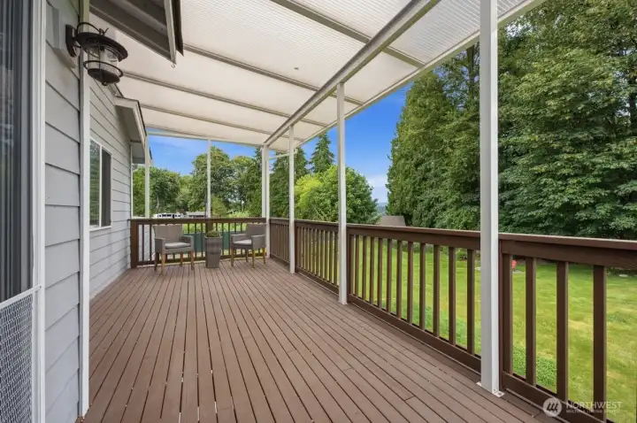 Deck space off of kitchen overlooking backyard and trees.