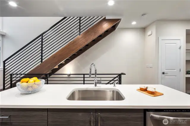 Stairs from the lifestyle level to the upper bedroom level are custom constructed and stained.  Metal railings add to the contemporary look.  The open stairs are a unique feature of these homes and allow natural light to flood through them.