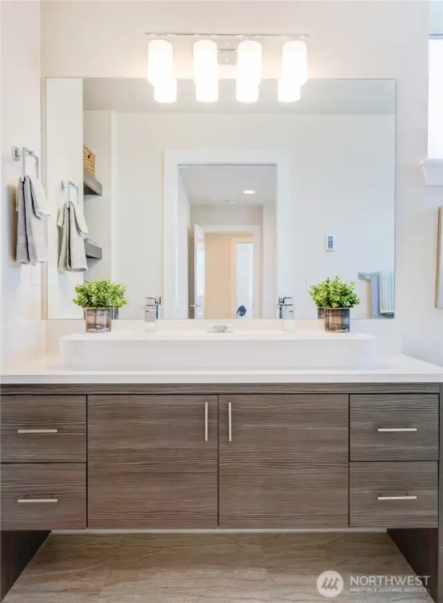 Primary bathroom of one of the Avenue plans.  All homes have primary bathrooms that feature walk in tiled showers + built in shelving for storage + modern cabinetry + natural light + quartz counters and Grohe fixtures.