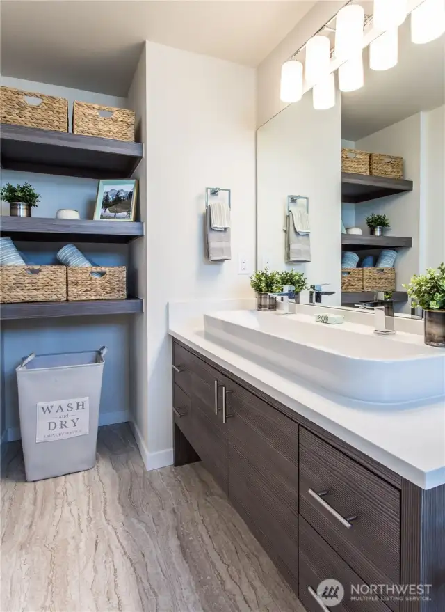 Primary bathroom of one of the Avenue plans.  All homes have primary bathrooms that feature walk in tiled showers + built in shelving for storage + modern cabinetry + natural light + quartz counters and Grohe fixtures.