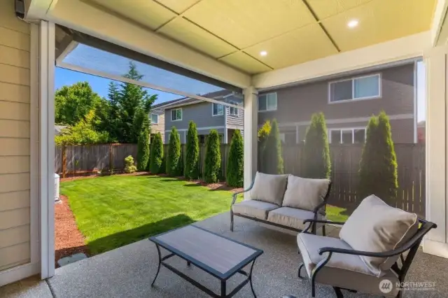One of the great improvements to the home has been the extended covered patio with motorized low UV screens. Notice the screen here on the left is partially down, which the back screen is all the way down. You can enclose the entire patio in screens, fully or partially lowered.