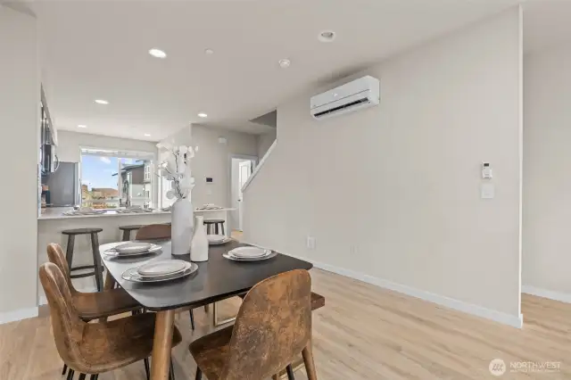 Bright and open living room with oversized windows, luxury vinyl plank flooring, and mini-split heating and A/C.