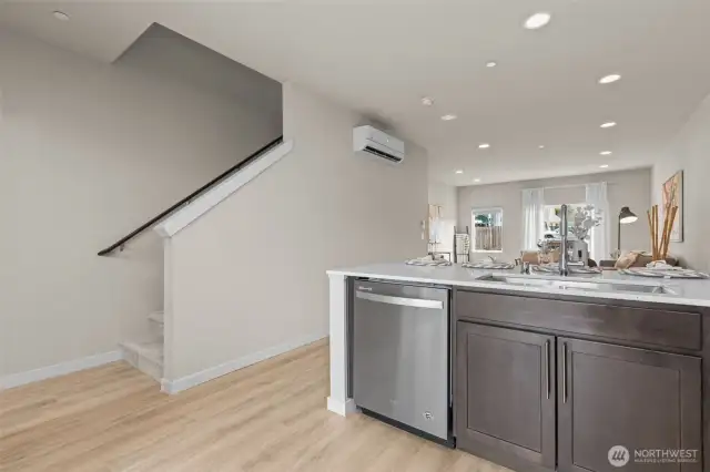 Contemporary kitchen with stainless steel appliances, quartz countertops, and full-height tile backsplash.