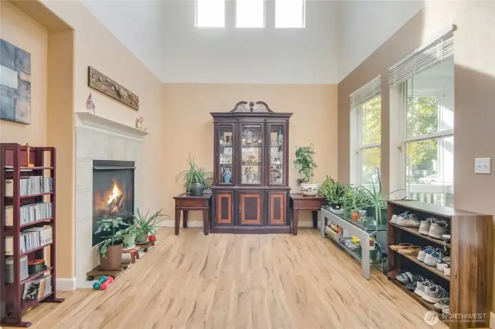 Formal living room area has a high ceiling, updated floorings and gas fireplace