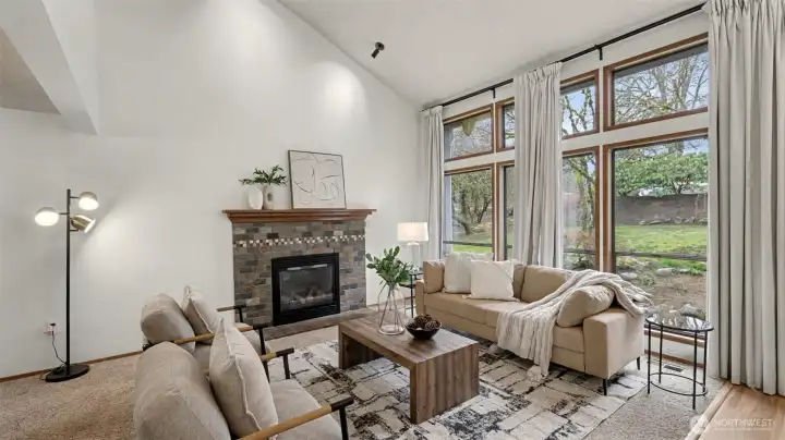 A cozy yet elevated living space featuring a statement fireplace and walls of windows that bring the outdoors in.