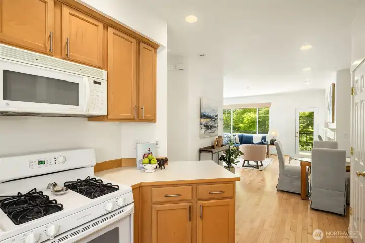 Looking from the kitchen towards the eating area and the living room beyond. The door you see to the right is the pantry, and the access door to the attached 1-car garage is in between the pantry and the kitchen.