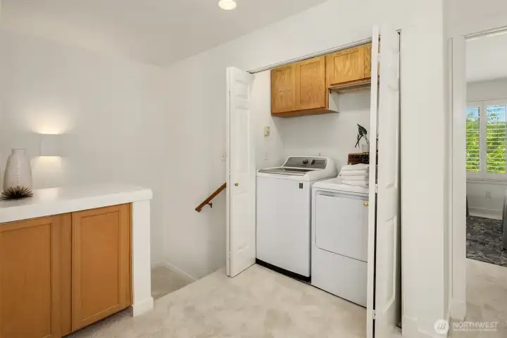 Heading up the stairs, you'll come to this landing where the washer dryer is located, a linen cupboard, and access to the secondary bedroom with adjacent full bath and primary ensuite.